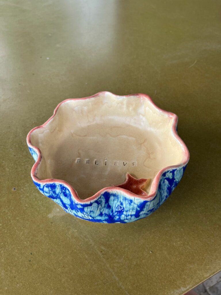 Bol en céramique façonné à la main avec bord ondulé rose.