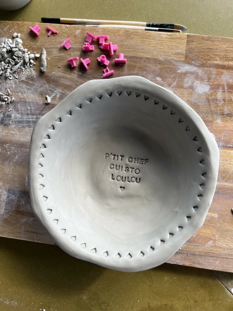 Plat artisanal en céramique gravé avec message personnalisé.